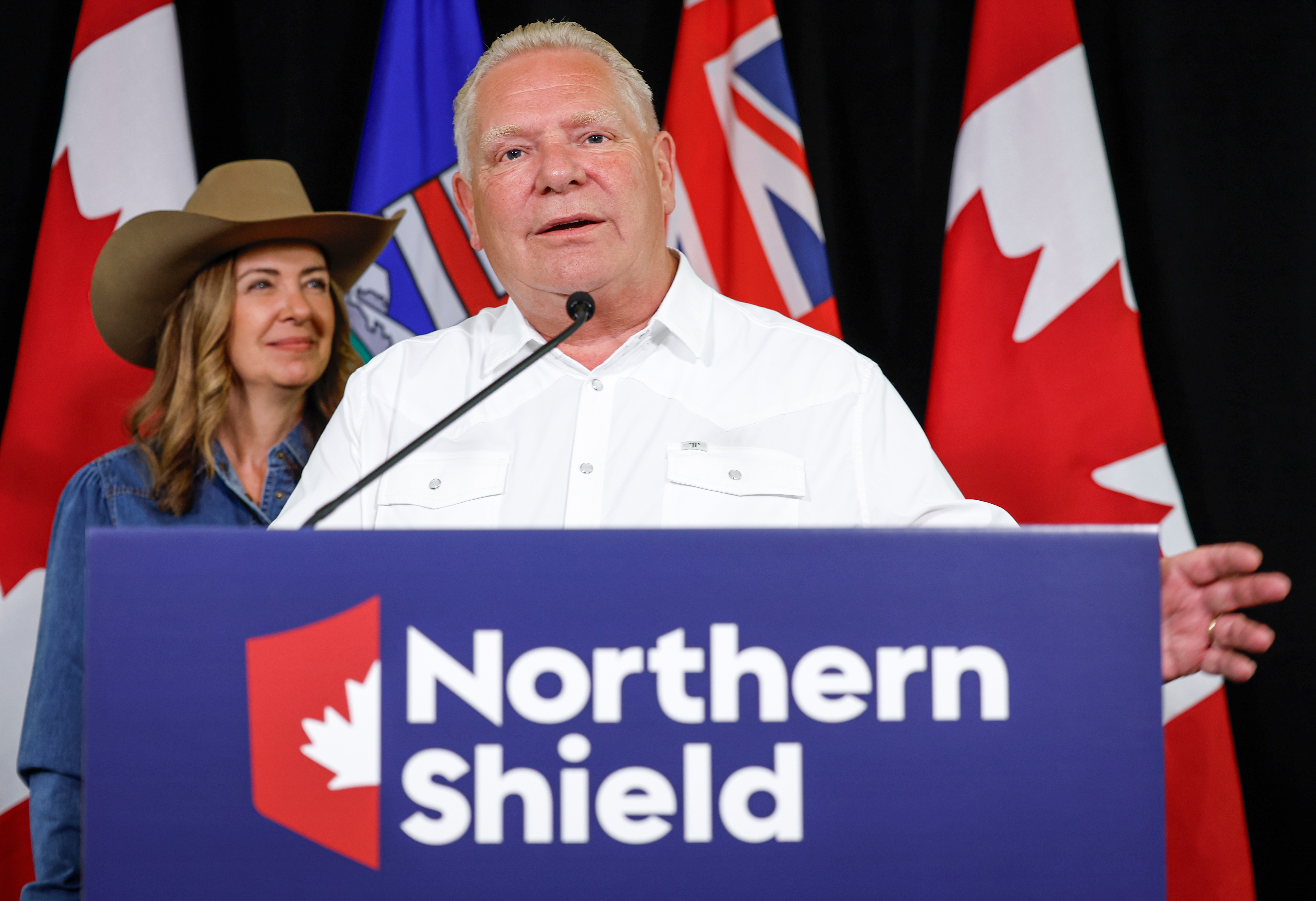 Ontario Premier Doug Ford speaking with Alberta Premier Danielle Smith behind him, the original Associated Press photograph