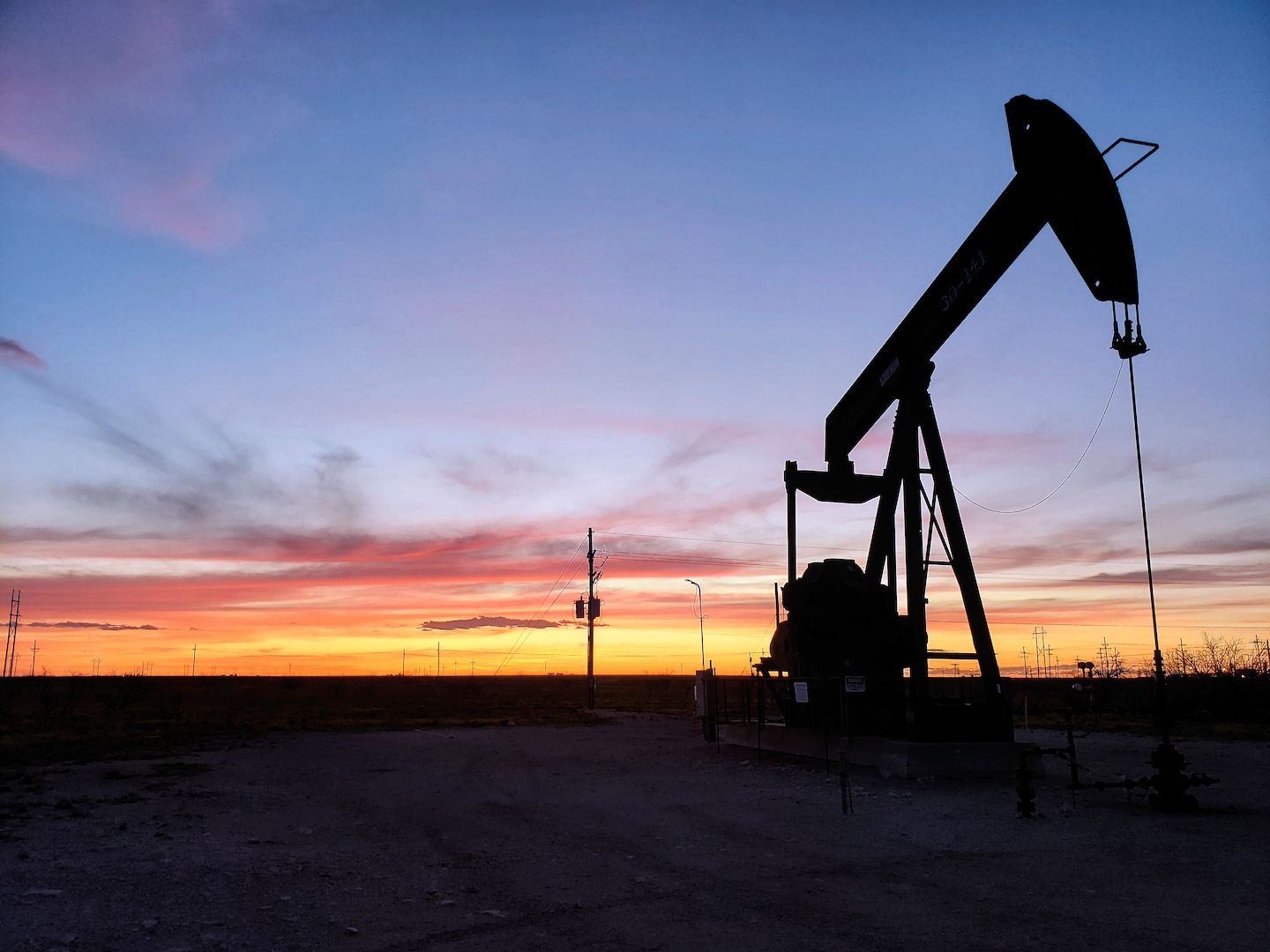 Original Washington Post lead photograph of an oil pumpjack at sunset